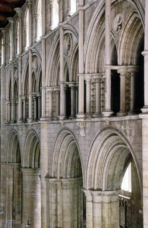 Architecture. Three levels of stone arches angle away from us to the left in this church interior. Detached shafts, commonly likened to flagpoles, have been added in front of the double arches on the middle level.